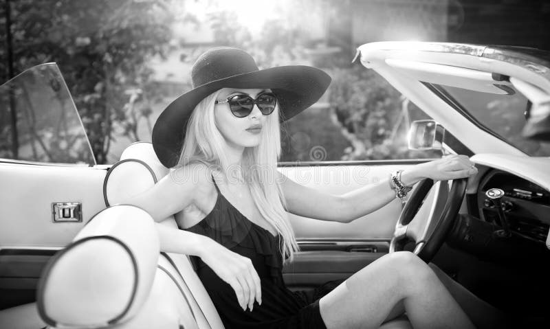 Retrato al aire libre del verano de la mujer rubia elegante del vintage que conduce un coche retro convertible fotografía de archivo Retrato al aire libre del verano de la mujer rubia elegante del vintage que conduce un coche retro convertible fotografía de archivo