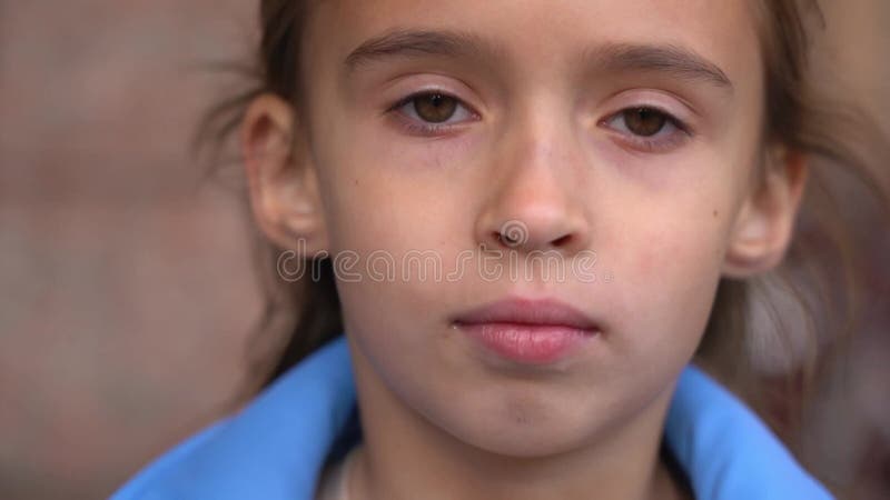 Retrato aproximado de uma menina caucasiana séria olhando para a câmera