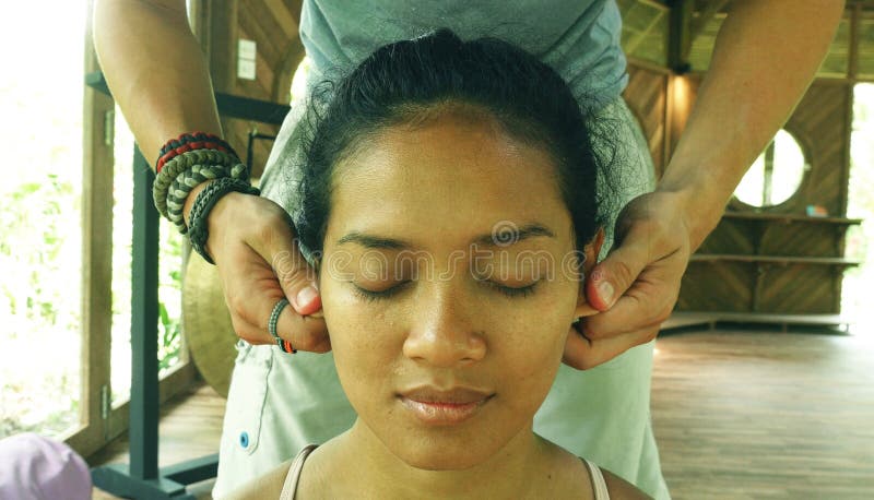Retrato ascendente próximo da cara da mulher indonésia asiática lindo e relaxado nova que recebe a massagem tailandesa facial tra fotografia de stock Retrato ascendente próximo da cara da mulher indonésia asiática lindo e relaxado nova que recebe a massagem tailandesa facial tra fotografia de stock
