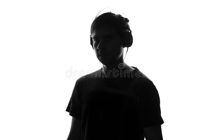 Retrato blanco y negro aislado de un adolescente que escucha la música en auriculares grandes fotos de archivo libres de regalías Retrato blanco y negro aislado de un adolescente que escucha la música en auriculares grandes fotos de archivo libres de regalías