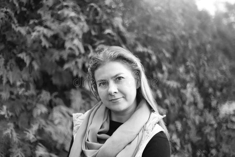 Retrato blanco y negro mujer bastante caucásica 35 mirando la cámara con una bufanda. ropa casual para caminar. fondo verde. deporte. yoga. concepto de estilo de vida