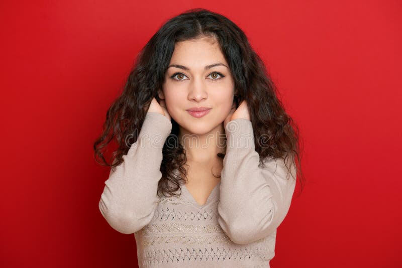 Retrato bonito da jovem mulher com cabelo ondulado longo preto no vermelho fotografia de stock royalty free Retrato bonito da jovem mulher com cabelo ondulado longo preto no vermelho fotografia de stock royalty free
