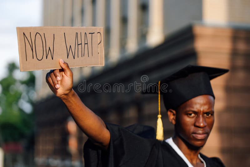 Retrato cerrado de un hombre negro sosteniendo en la mano un cartel de cartón levantado en la calle buscando trabajo con enfoque s