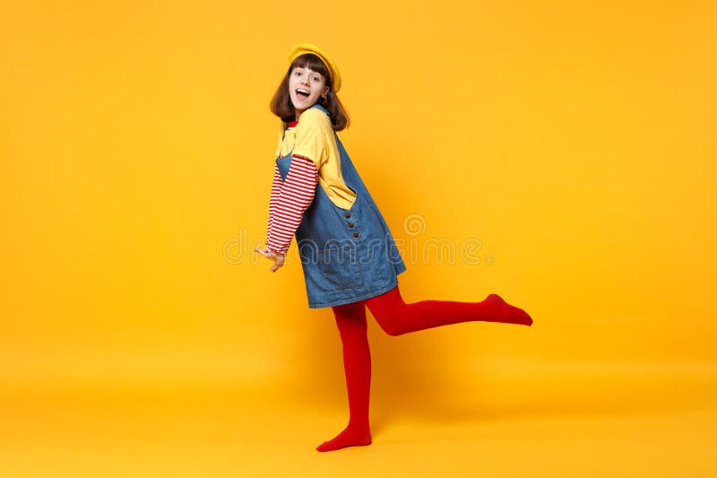 Retrato completo do comprimento do adolescente entusiasmado da menina na posição francesa dos sundress da boina e da sarja de Nim imagens de stock royalty free Retrato completo do comprimento do adolescente entusiasmado da menina na posição francesa dos sundress da boina e da sarja de Nim imagens de stock royalty free