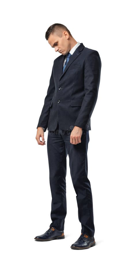 Retrato completo do crescimento do homem de negócios que está com o triste principal e olhando curvado isolado no fundo branco imagens de stock Retrato completo do crescimento do homem de negócios que está com o triste principal e olhando curvado isolado no fundo branco imagens de stock