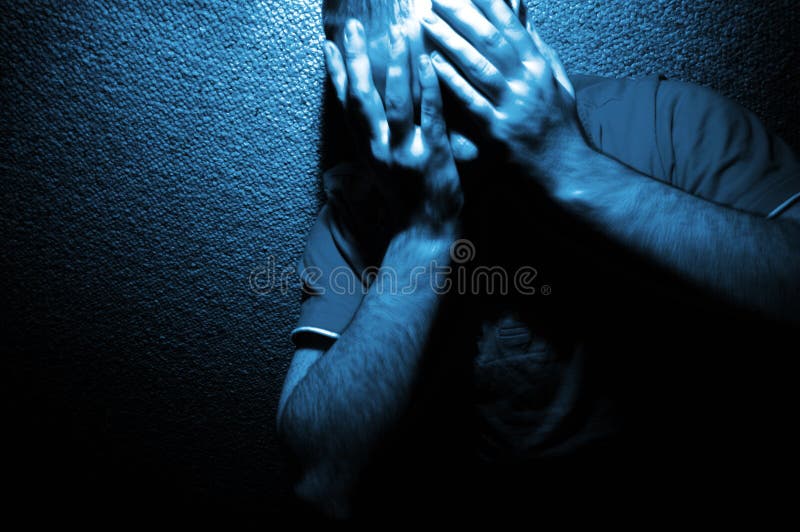 Dramatic blue-toned photo of a man leaning against a wall with his hands over his eyes...portrays anguish, depression, grief or frustration. Dramatic blue-toned photo of a man leaning against a wall with his hands over his eyes...portrays anguish, depression, grief or frustration.