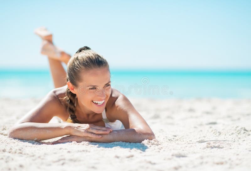 Retrato da jovem mulher de sorriso que coloca na praia