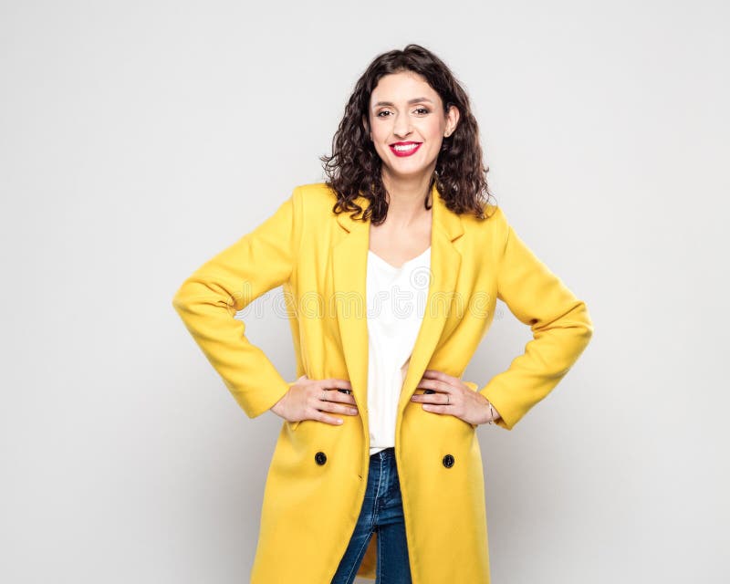 Retrato da jovem mulher feliz no revestimento amarelo imagens de stock royalty free Retrato da jovem mulher feliz no revestimento amarelo imagens de stock royalty free