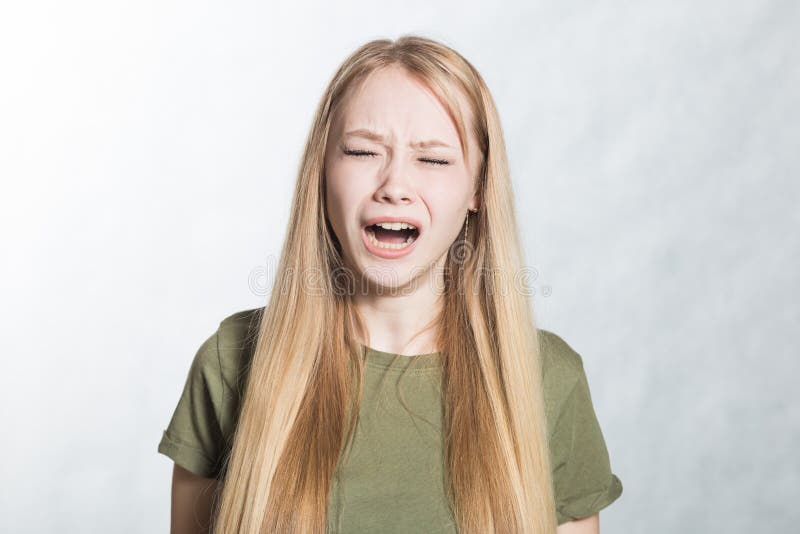 Retrato da jovem mulher gritando irritada no fundo cinzento imagens de stock royalty free Retrato da jovem mulher gritando irritada no fundo cinzento imagens de stock royalty free