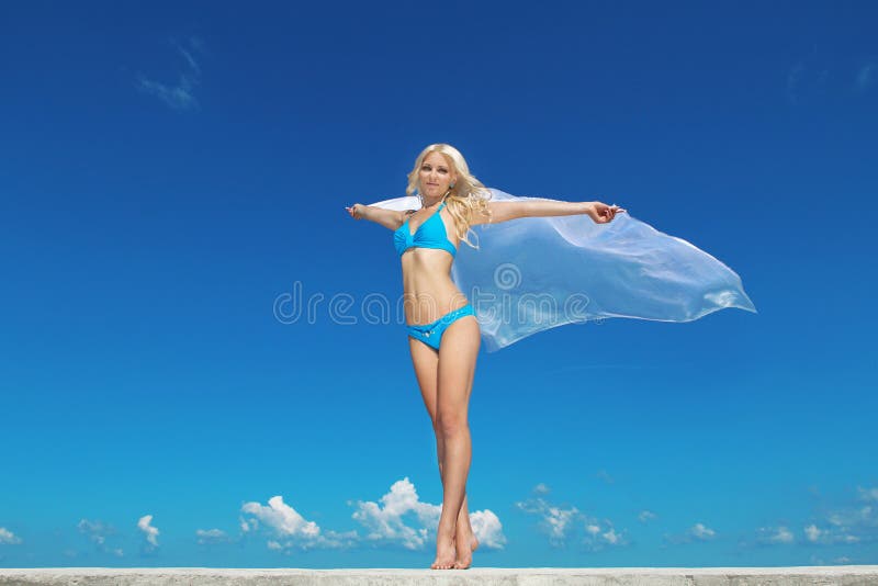 Portrait of young woman feeling free against blue sky with blowing fabric. Freedom Concept. Portrait of young woman feeling free against blue sky with blowing fabric. Freedom Concept