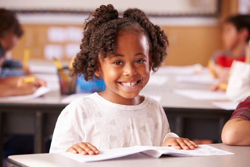 Retrato da menina afro-americano da escola primária na classe