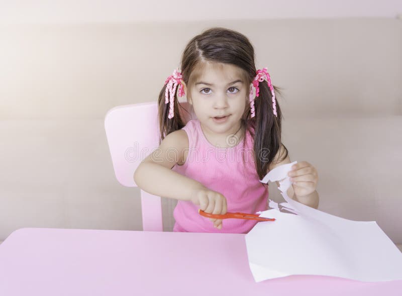 Retrato da menina bonito que corta o papel apenas com tesouras imagem de stock Retrato da menina bonito que corta o papel apenas com tesouras imagem de stock