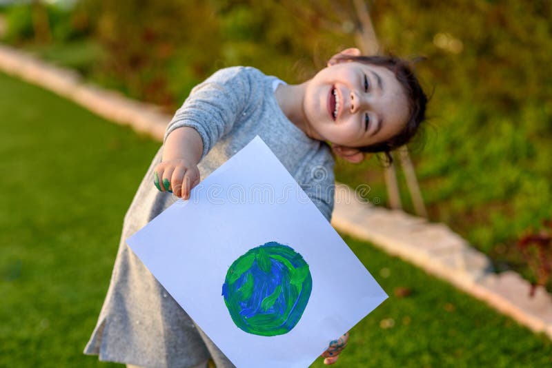 Retrato da menina bonito que guarda o globo de tiragem da terra Drawng da criança uma imagem da terra imagem de stock royalty free Retrato da menina bonito que guarda o globo de tiragem da terra Drawng da criança uma imagem da terra imagem de stock royalty free