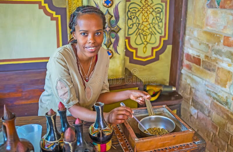 KIEV, UKRAINE - JUNE 4, 2017: The portrait of young Tigrayan woman at work - she prepares coffee beans for the ethnic Ethiopian coffee ceremony, on June 4 in Kiev. KIEV, UKRAINE - JUNE 4, 2017: The portrait of young Tigrayan woman at work - she prepares coffee beans for the ethnic Ethiopian coffee ceremony, on June 4 in Kiev.