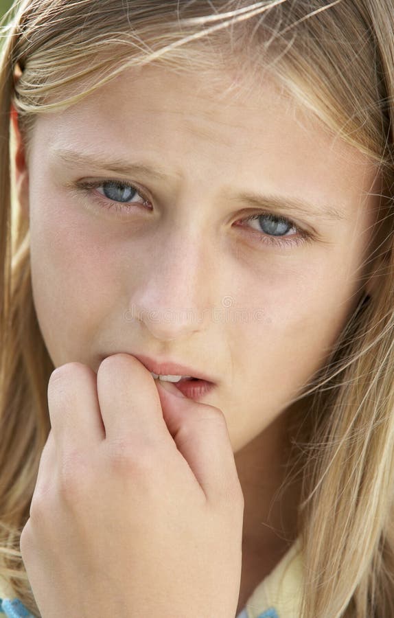 Retrato da menina do Pre-Teen que morde seus pregos imagem de stock royalty free Retrato da menina do Pre-Teen que morde seus pregos imagem de stock royalty free