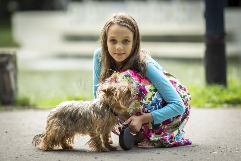 Retrato da menina em uma caminhada com seu cão pequeno imagens de stock royalty free Retrato da menina em uma caminhada com seu cão pequeno imagens de stock royalty free