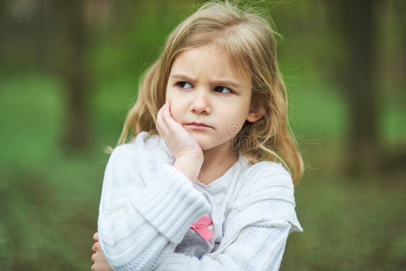 Retrato da menina infeliz triste A criança triste pequena é solitária expressão facial irritada virada e desassossegado fotografia de stock Retrato da menina infeliz triste A criança triste pequena é solitária expressão facial irritada virada e desassossegado fotografia de stock