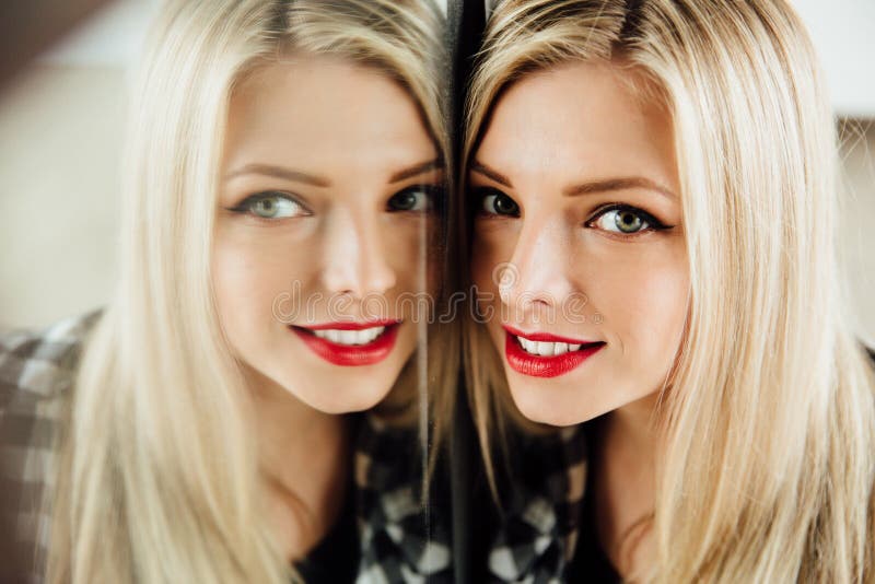 Retrato da menina loura da jovem mulher bonita e da sua reflexão no espelho fotografia de stock Retrato da menina loura da jovem mulher bonita e da sua reflexão no espelho fotografia de stock