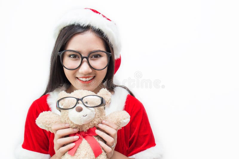 Retrato da mulher bonita asiática que vestem o custume de Santa e dos vidros que guardam o urso de peluche imagem de stock Retrato da mulher bonita asiática que vestem o custume de Santa e dos vidros que guardam o urso de peluche imagem de stock