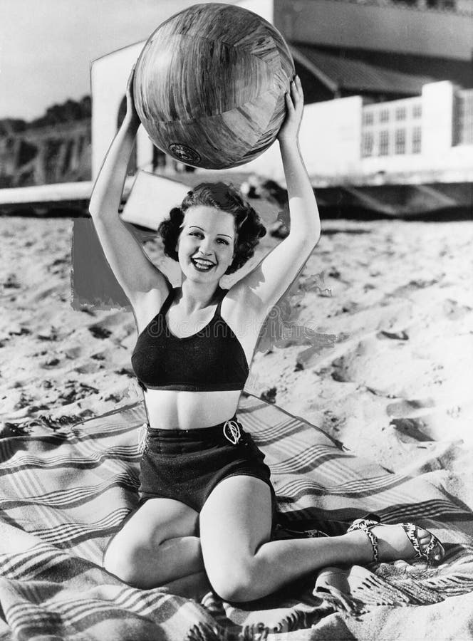 Portrait of woman with ball at beach (All persons depicted are no longer living and no estate exists. Supplier grants that there will be no model release issues.). Portrait of woman with ball at beach (All persons depicted are no longer living and no estate exists. Supplier grants that there will be no model release issues.)