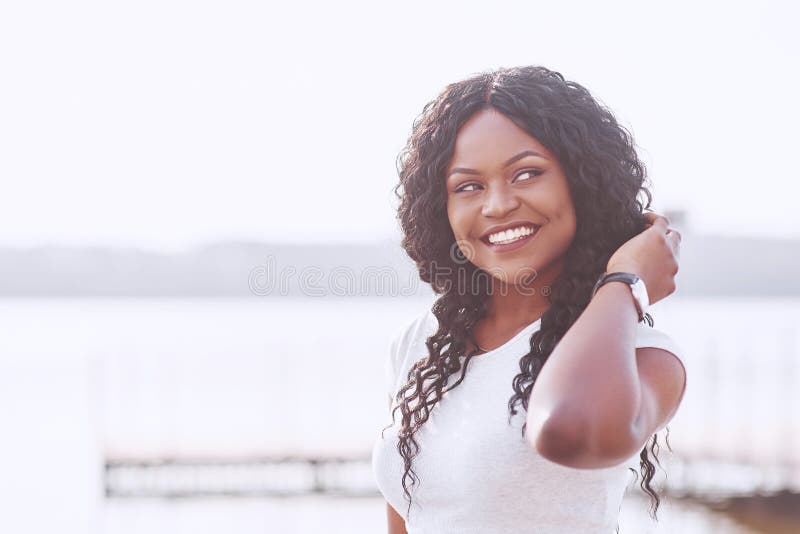Retrato da mulher negra nova de sorriso com alargamento da luz solar fotos de stock Retrato da mulher negra nova de sorriso com alargamento da luz solar fotos de stock