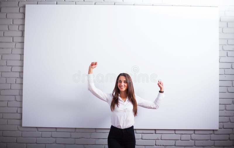 Retrato da mulher nova feliz da mulher de negócios perto na parede branca imagens de stock Retrato da mulher nova feliz da mulher de negócios perto na parede branca imagens de stock
