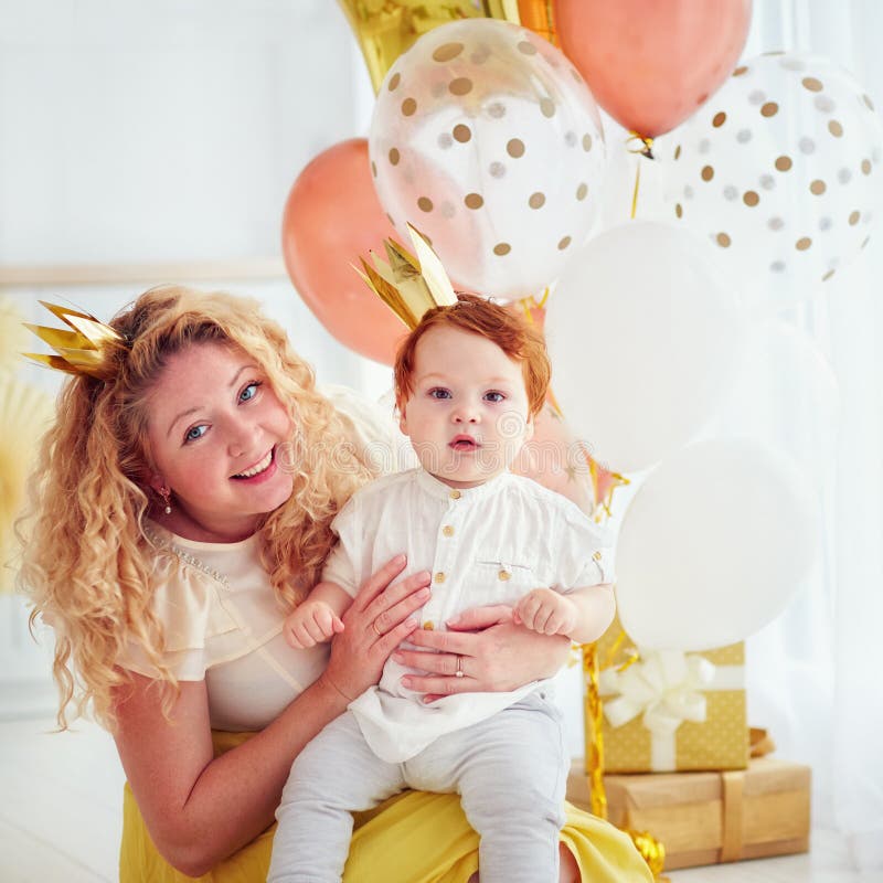 Retrato da mãe e do bebê pequeno bonito em sua ?a festa de anos imagem de stock Retrato da mãe e do bebê pequeno bonito em sua ?a festa de anos imagem de stock