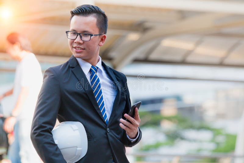 Retrato da mão nova moderna segura do terno do preto do desgaste do homem de negócios que guarda a tabuleta digital fotografia de stock Retrato da mão nova moderna segura do terno do preto do desgaste do homem de negócios que guarda a tabuleta digital fotografia de stock