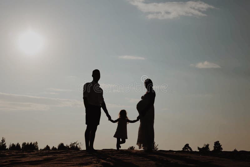 Retrato da silhueta da família nova bonita na expectativa de recém-nascido Homem e mulher que estão cara a cara com seu fotos de stock royalty free Retrato da silhueta da família nova bonita na expectativa de recém-nascido Homem e mulher que estão cara a cara com seu fotos de stock royalty free
