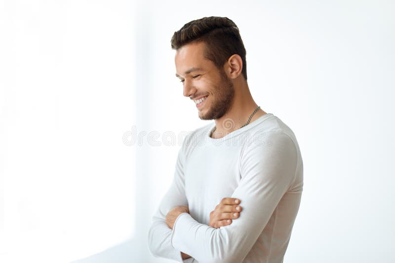 Retrato da vista lateral do homem considerável de sorriso no fundo branco
