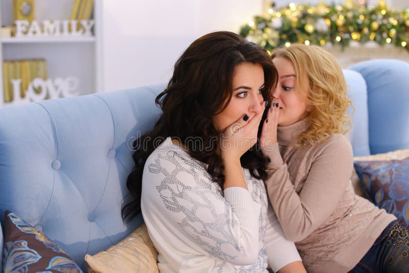 Retrato das amigas bonitas que discutem a bisbolhetice e se sentam sobre imagens de stock royalty free Retrato das amigas bonitas que discutem a bisbolhetice e se sentam sobre imagens de stock royalty free