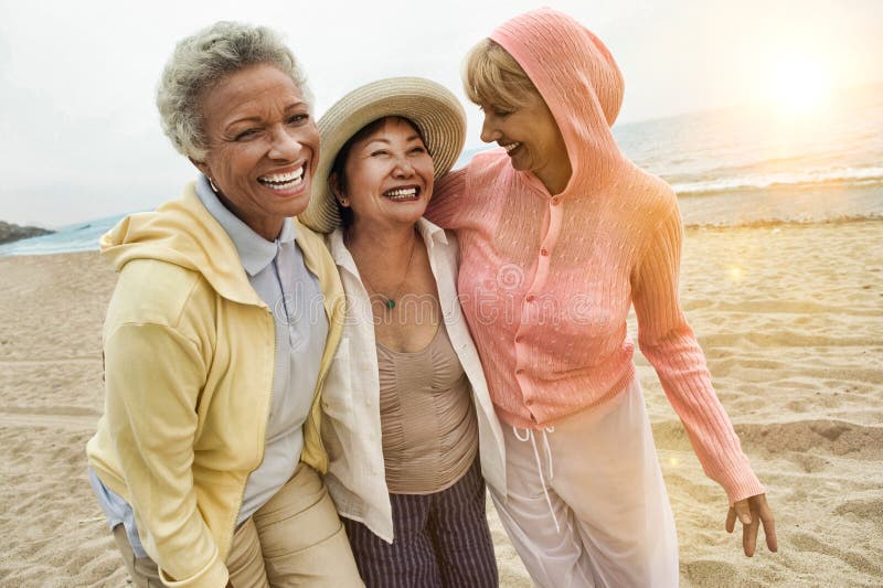 Photo of happy multi ethnic middle aged female friends enjoying vacation at beach. Photo of happy multi ethnic middle aged female friends enjoying vacation at beach