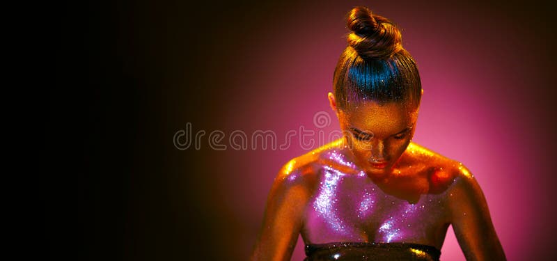 Retrato de arte de moda. modelo chica con colores brillantes brillantes dorado y piel rosa luces de neón posando en estudio hermos