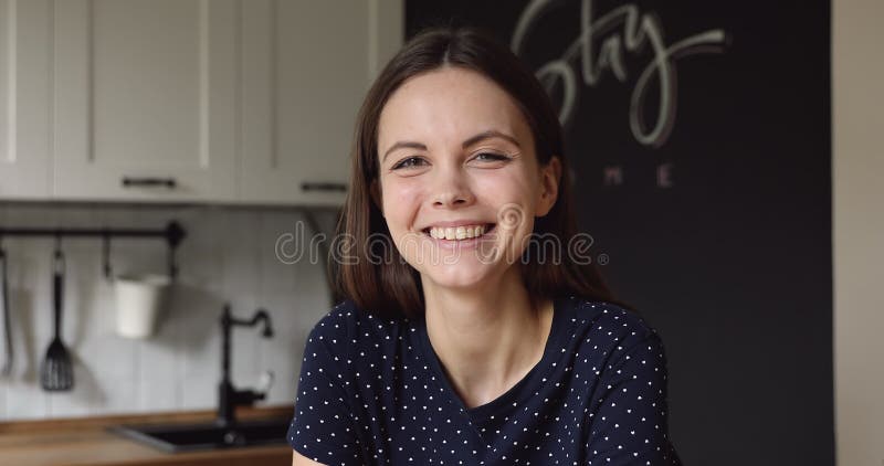 Retrato de cabeza de una atractiva joven sonriendo mirando la cámara almacen de metraje de vídeo