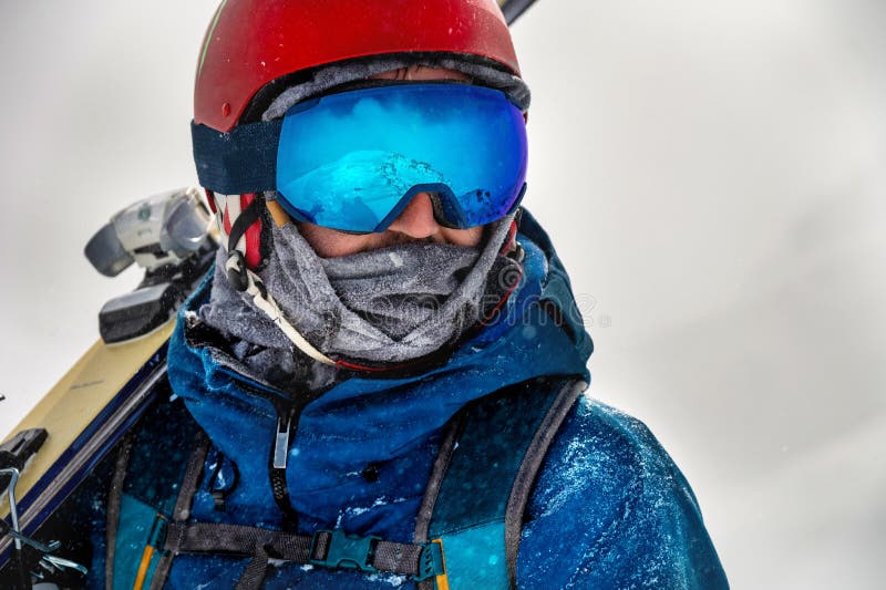 Cerca de las gafas de esquí de un hombre con el reflejo de las montañas  nevadas