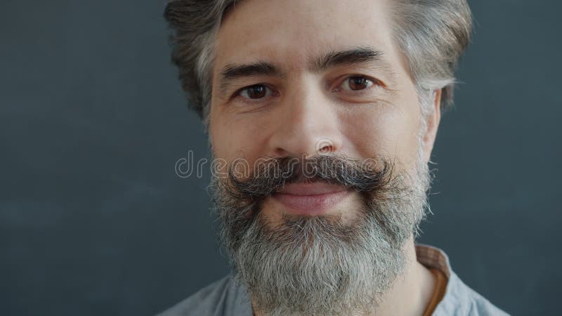 Retrato de cerca de un hombre maduro y guapo sonriendo y riendo mirando la cámara almacen de metraje de vídeo