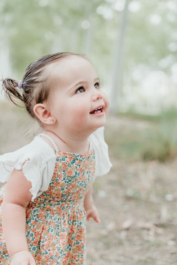 Retrato de cerca de una bella niña feliz que se divierte al aire libre en el camino de los árboles. concepto de diversión infantil imagen de archivo