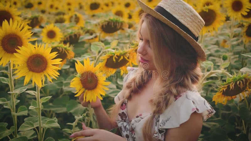 Retrato de clausura joven feliz mujer hermosa. Niña sostiene girasol amarillo en las manos adivinen los amores a la flor y no les almacen de video