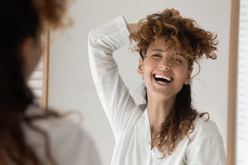 Retrato de disparo de cabeza divertida mujer alegre mirando en el espejo fotografía de archivo