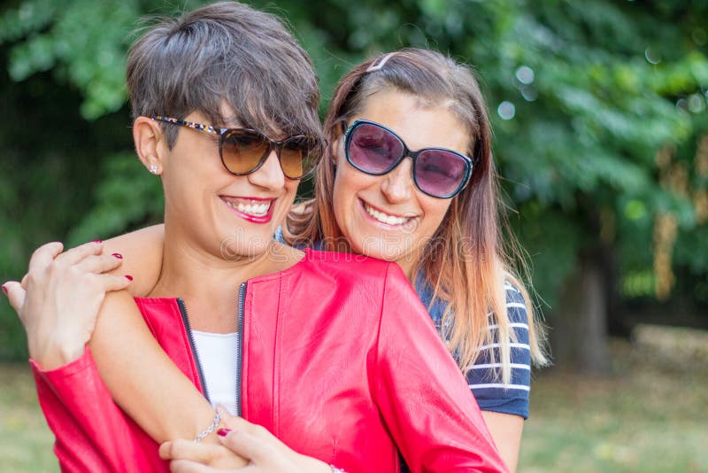 Retrato De Dos Jóvenes Lesbianas Sonrientes Abrazándose En Un Día De Verano  Con Ropa De Camisa Y Jeans De Color Foto de archivo - Imagen de lesbianas,  gente: 185631012