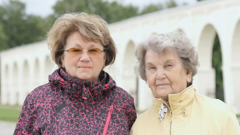 Retrato de dos mujeres adultas positivas al aire libre