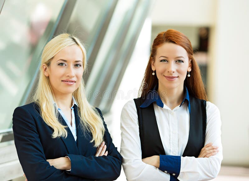 Retrato de dos mujeres de negocios felices confiadas fotografía de archivo libre de regalías Retrato de dos mujeres de negocios felices confiadas fotografía de archivo libre de regalías