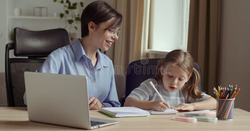 Retrato de dos mujeres, una joven sonriente usa computadora para la presentación en clase con un pequeño preescolar lindo