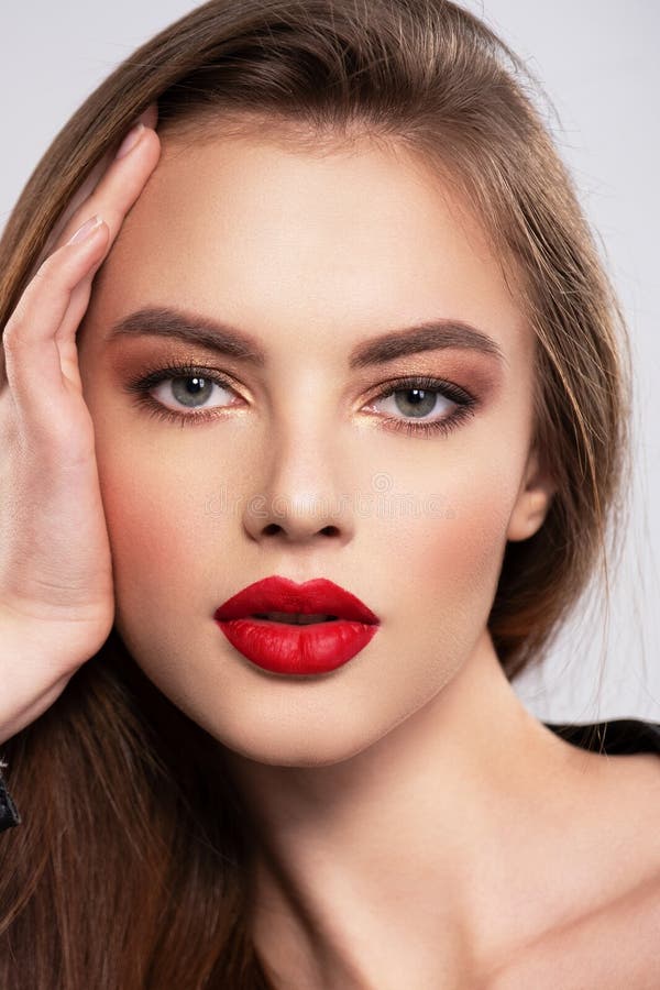 Retrato de hermosa joven con maquillaje brillante. bella morena con lápiz labial rojo brillante en sus labios. linda chica con fotografía de archivo libre de regalías