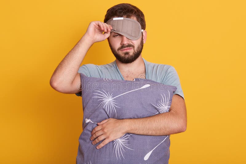 Retrato de hombre barbudo vestido con traje y mascarilla para dormir en su cabeza, quiere seguir durmiendo, no despertar en la maà foto de archivo libre de regalías Retrato de hombre barbudo vestido con traje y mascarilla para dormir en su cabeza, quiere seguir durmiendo, no despertar en la maà foto de archivo libre de regalías