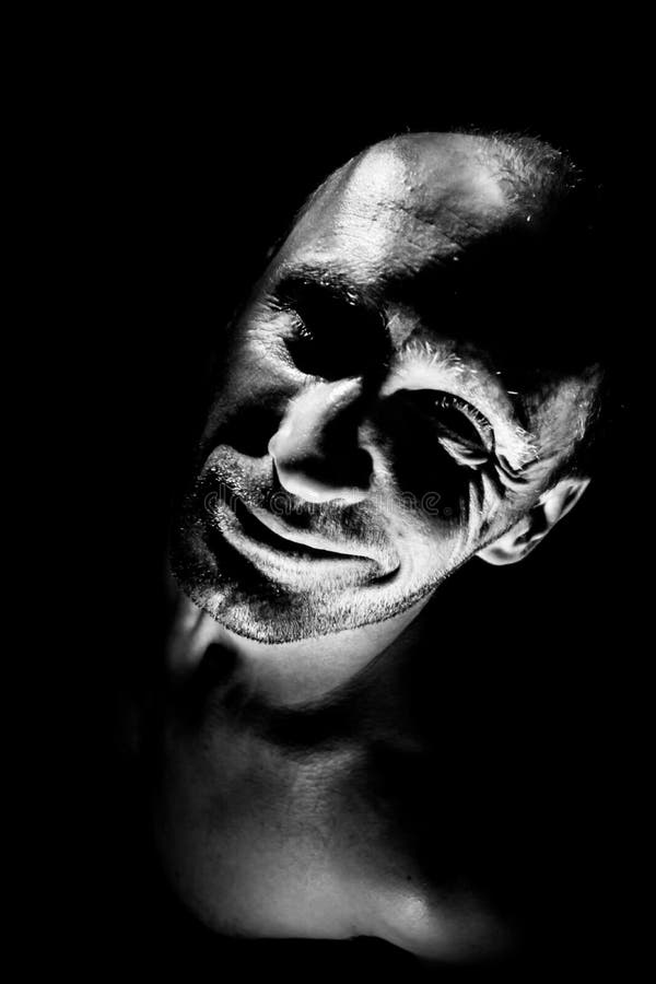Retrato de hombre caucásico adulto. sonríe como maniático y parece locura. iluminación en blanco y negro de disparo. aislado fotos de archivo libres de regalías