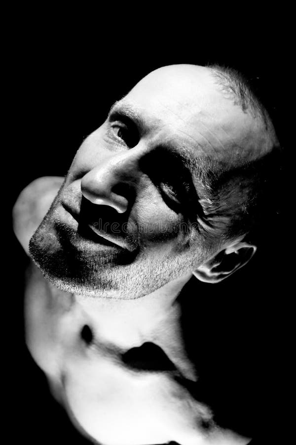 Retrato de hombre caucásico adulto. sonríe como maniático y parece locura. iluminación en blanco y negro de disparo. aislado imagen de archivo