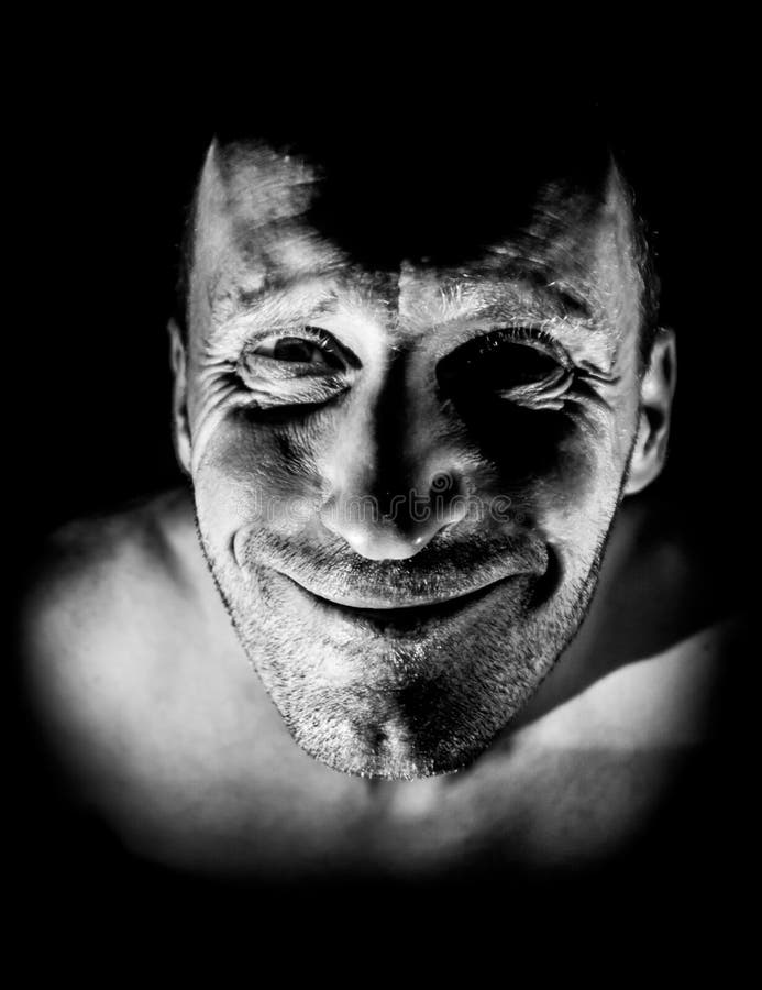 Retrato de hombre caucásico adulto. sonríe como maniático y parece locura. iluminación en blanco y negro de disparo. aislado fotografía de archivo