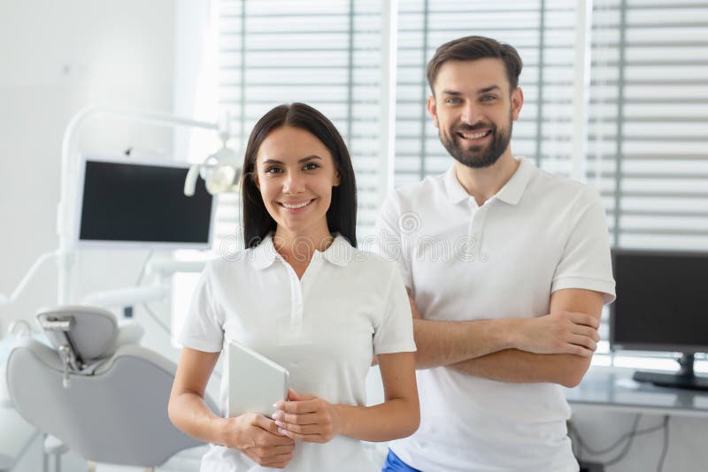 Portrait of young male and female dentists looking at camera in dental office dental. Portrait of young male and female dentists looking at camera in dental office dental