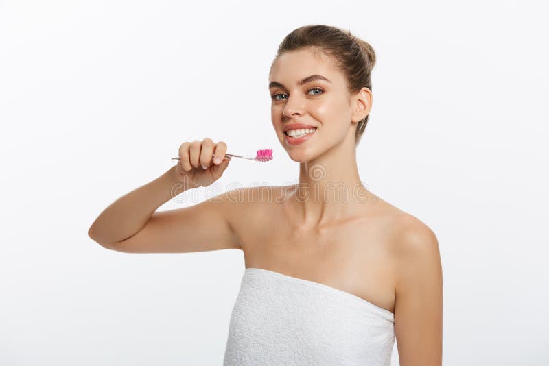 Retrato de la belleza de una media mujer desnuda hermosa feliz que cepilla sus dientes con un cepillo de dientes y que mira la cá imágenes de archivo libres de regalías Retrato de la belleza de una media mujer desnuda hermosa feliz que cepilla sus dientes con un cepillo de dientes y que mira la cá imágenes de archivo libres de regalías